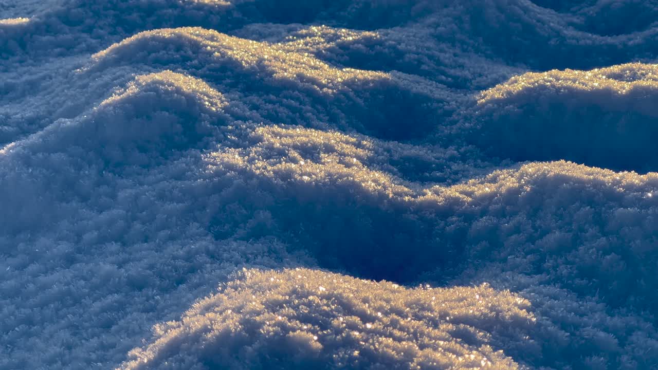 Blue snow dunes cover plowed field expanding towards horizon