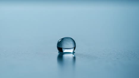 a close-up view of a water droplet reflecting light on a smooth surface, capturing the serenity and beauty of nature in minimalist elegance
