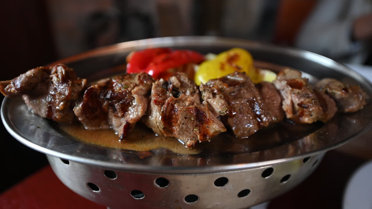 Close up of beef grilled meat on metallic plates at a traditional georgian restaurant