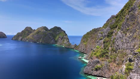 aerial view of secret beach at matinlo island in the philippines, featuring limestone cliffs, turquoise waters, lush greenery, and traditional boats along a serene tropical coastline