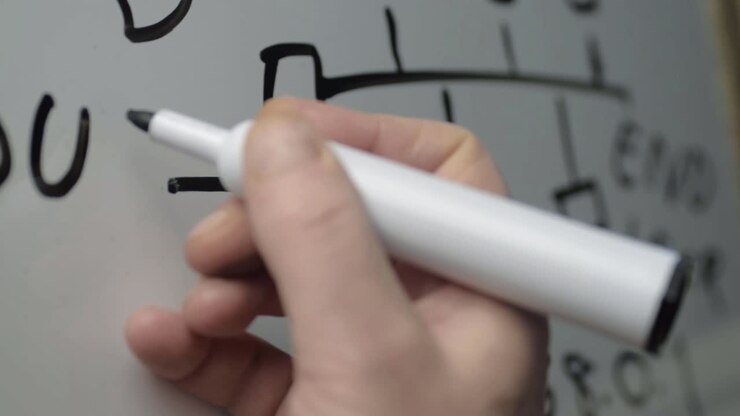 Hand designing computer cloud network on whiteboard panning close up shot