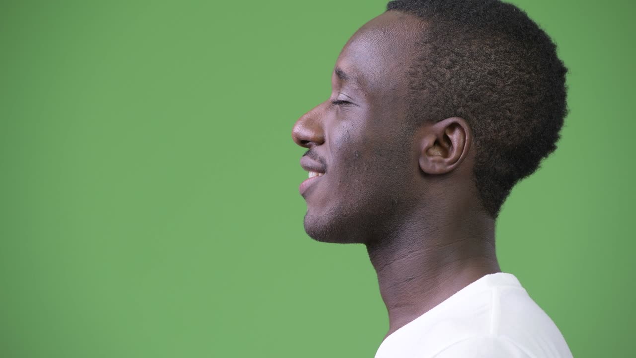 Profile view of young happy African man relaxing with eyes closed