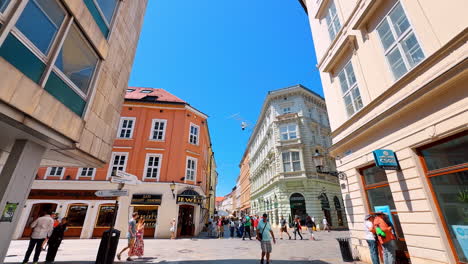 multiple tourists and locals walk by the old town. low angle view at the amazing architecture of bratislava, slovakia