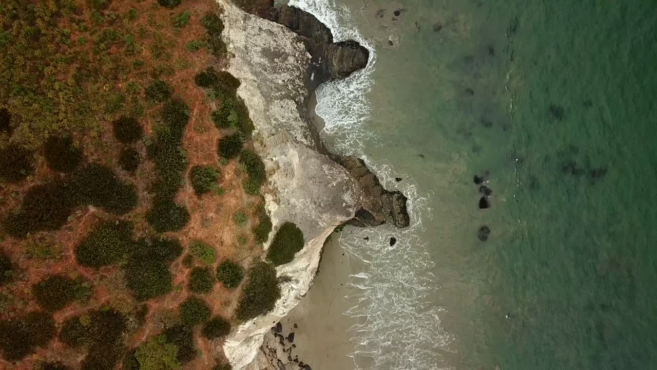Droneoptagelse af kystlinje og strand fra fugleperspektiv.