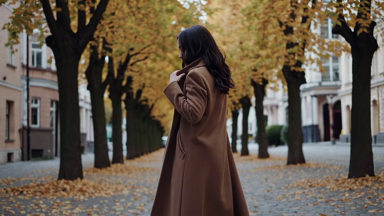 Donna che cammina lungo una strada alberata autunnale