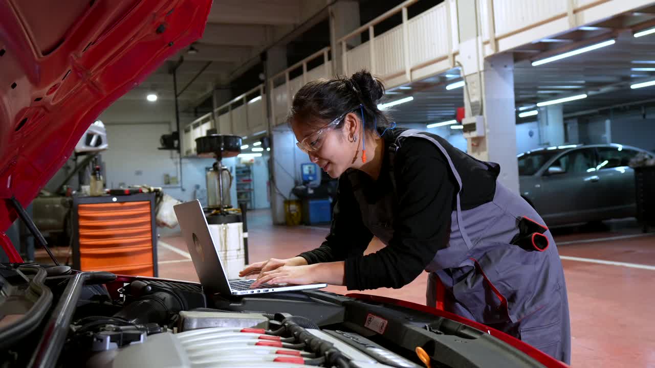 Female Mechanic Diagnosing Car Engine with Laptop