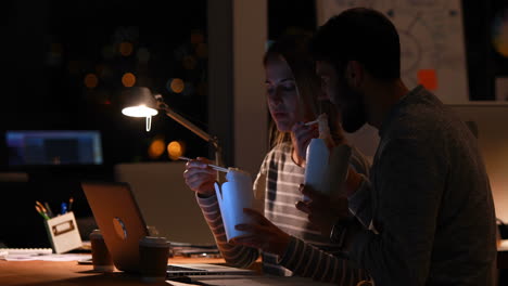 casual colleagues eating noodles at night