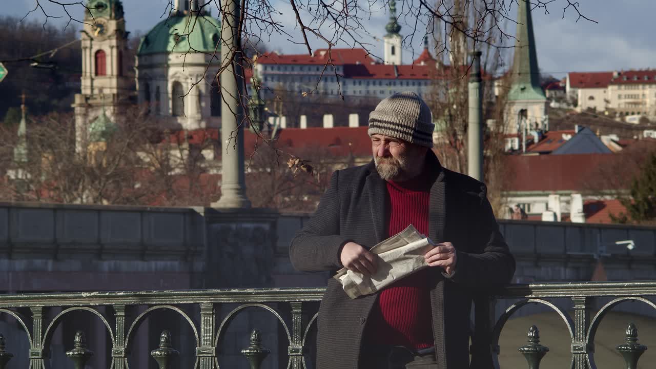 한 남자가 읽은 신문을 접으며 주위를 둘러본다