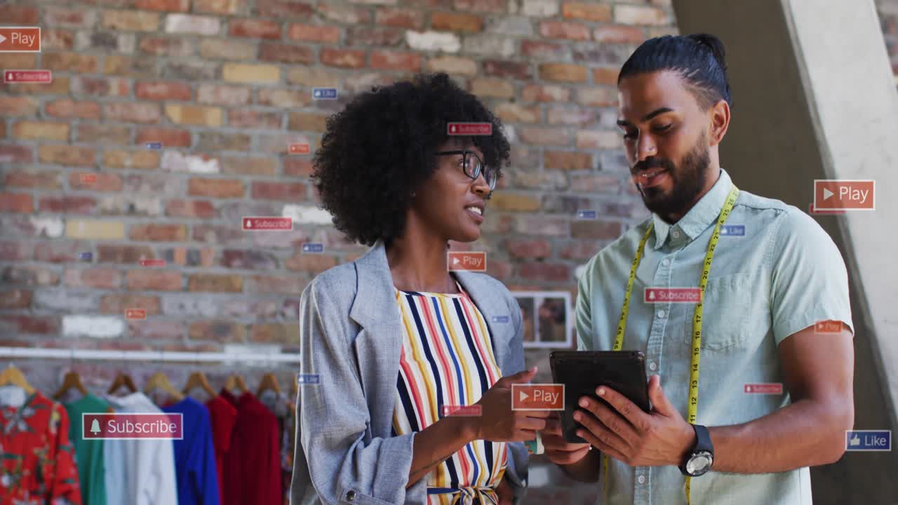Stylist pointing tablet and maker tapping in retail shop causing Subscribe Play icons checking fit