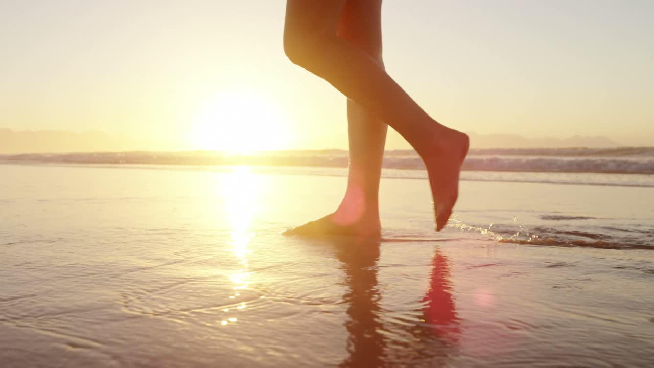 Donna che cammina sulla spiaggia al tramonto