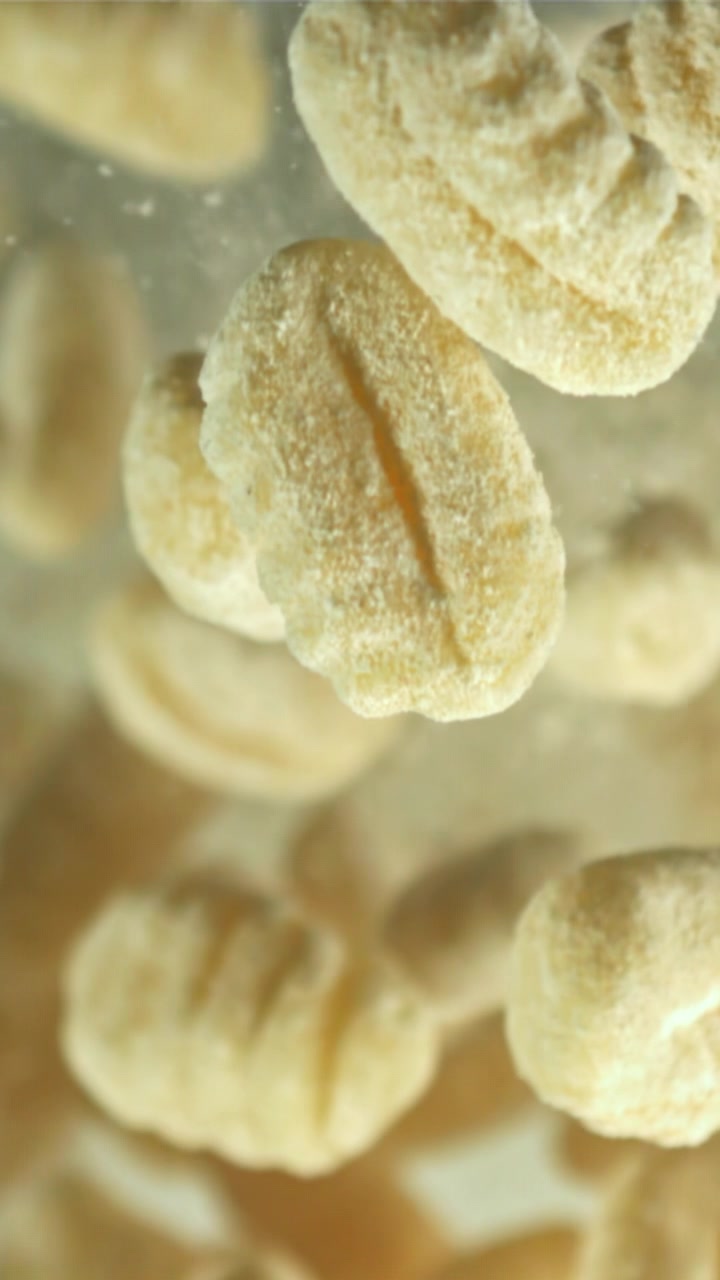 Primo piano di gnocchi crudi che cadono nell'acqua