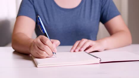 Close-Up-hands-taking-notes-on-a-notebook-about-planning-for-working-from-home-in-the-COVID-19-pandemic