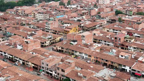 Dense-populated-slums-in-Medellin,-Colombia,-aerial-telephoto-dolly-forward