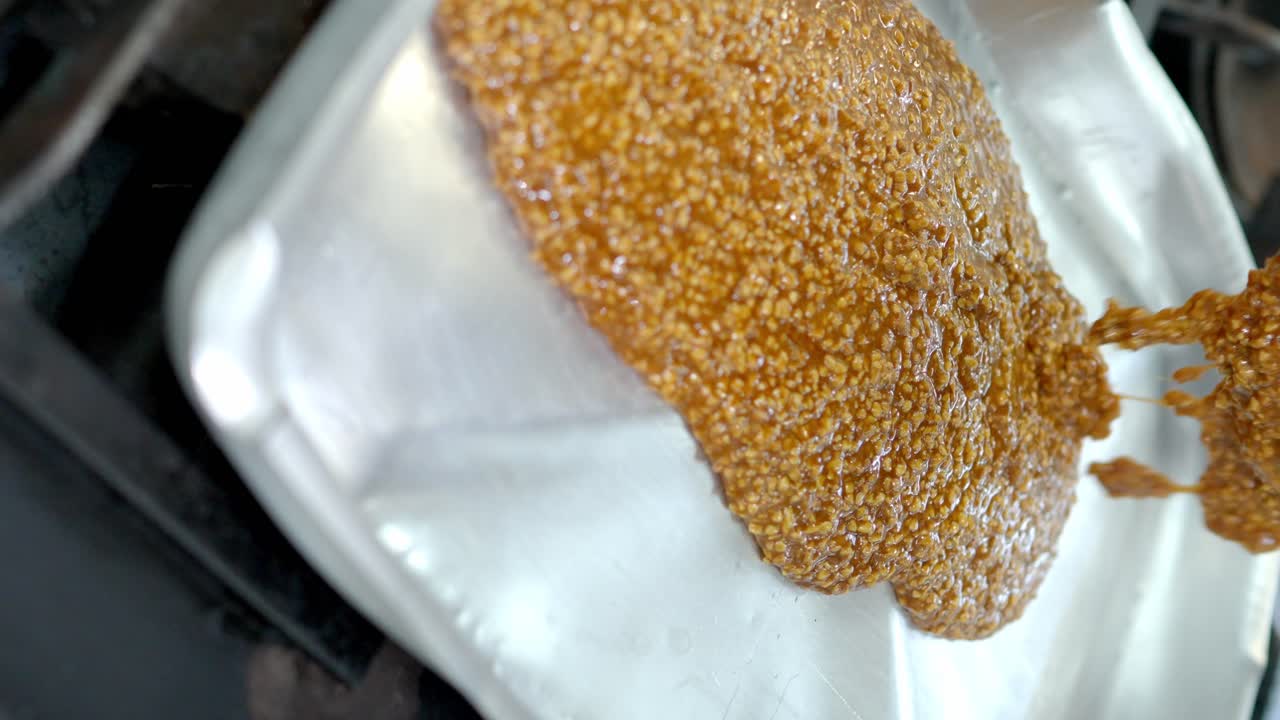 캐러멜화된 아몬드 크로켓을 만들기 위해 쟁반에 제공되는 뜨거운 캐러멜 으깬 아몬드