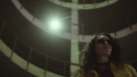 woman in sunglasses on street at night