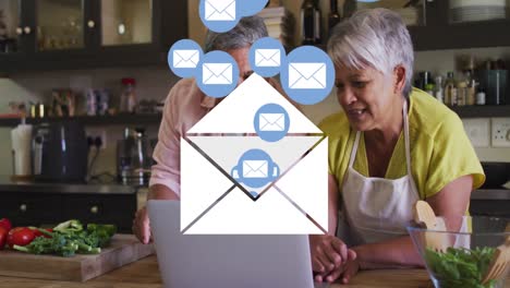 animation of envelope mail icons over senior couple using laptop at home