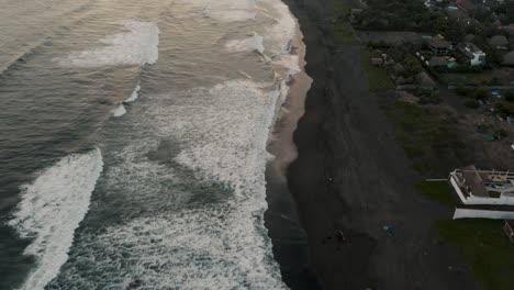 Volando-Sobre-La-Playa-De-Arena-Negra-En-El-Paredón,-Guatemala-Durante-La-Puesta-De-Sol---Disparo-De-Drones