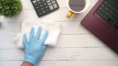 cleaning a white wooden desk with a laptop and calculator