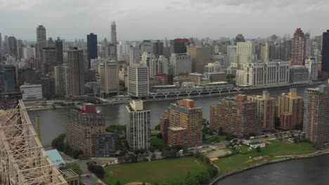 Drohnen-Luftaufnahme,-Die-Tagsüber-Von-Roosevelt-Island-Und-Queens-Neben-Der-Queensboro-Bridge-In-Richtung-Manhattan,-New-York,-Fliegt