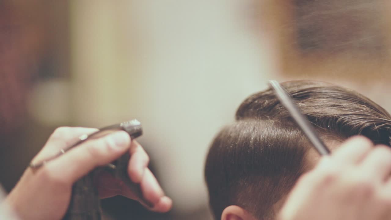 Mandeklip. Mandlig hårstyling. Barber styler hår. Mandlig frisering.