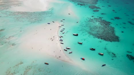 snorkeling tour boats in sand bank at mnemba island atoll near zanzibar,tanzania africa , aerial pan right shot