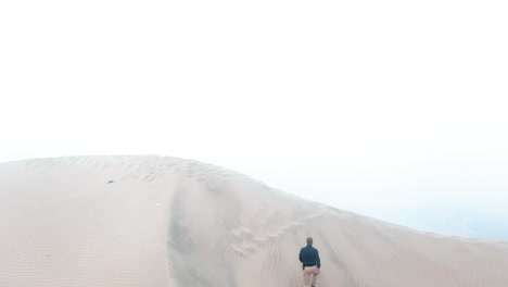 un hombre escalando una duna
