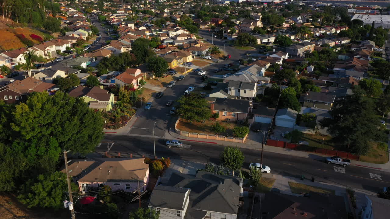 drone sigue a los autos que conducen a través de una calle residencial en los angeles california durante una fantástica puesta de sol, estados unidos, antena