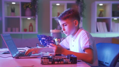 little boy working on electronic board and using computer.