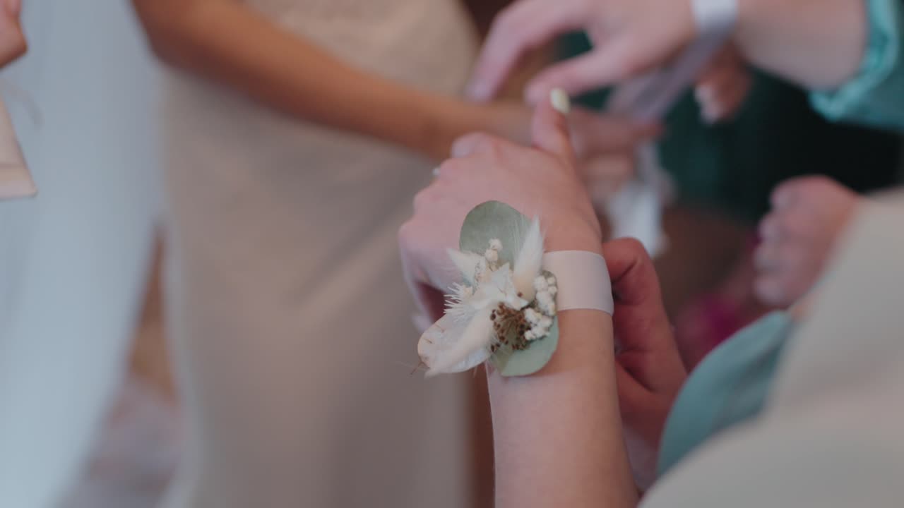 primer plano de un corsage de muñeca siendo ajustado en una boda