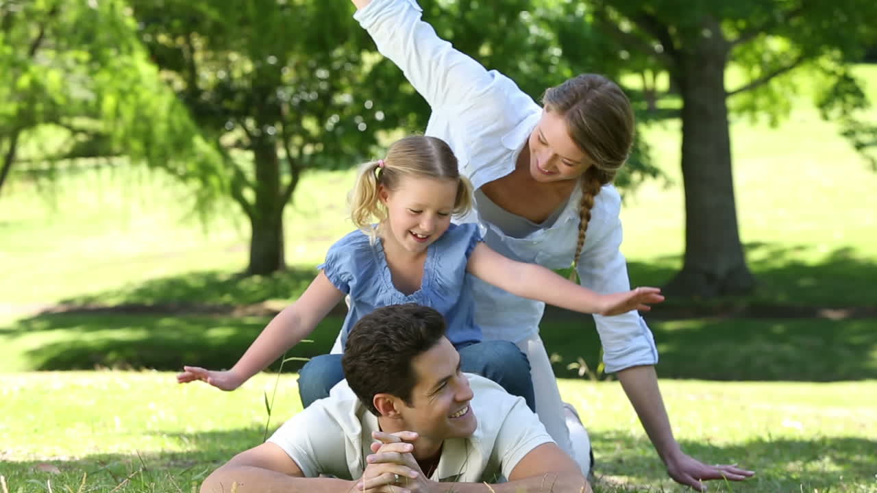 Pais felizes com a filha pequena no parque