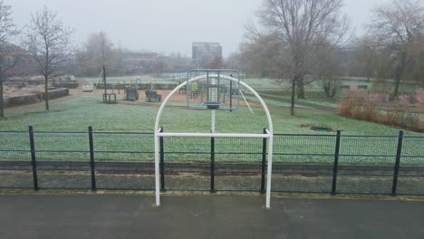 dolly out of metal hoop of urban basketball court on a cold and misty morning