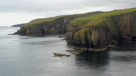 Revealing-drone-shot-of-Whaligoe-Haven-and-the-rocky-250ft-cliffs-overlooking-the-north-sea-in-Scotland