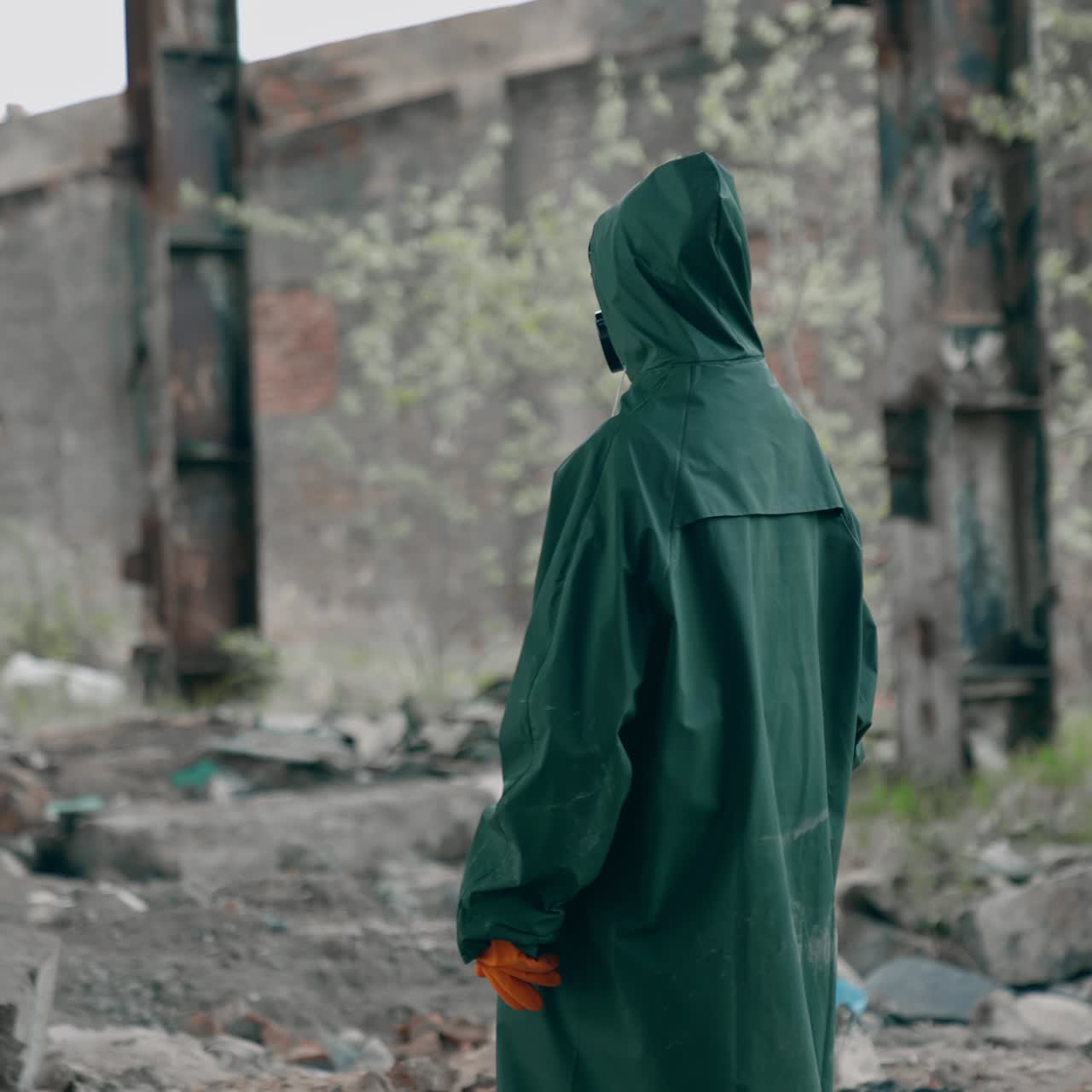 Man in a special suit in destroyed place. Human in chemical protective suit in ruined place. Post-apocalyptic world concept. Real background of abandoned place