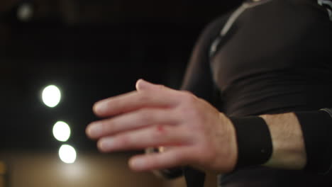 Unrecognizable-man-wrapping-hands-at-gym.-Male-hands-getting-ready-for-fight