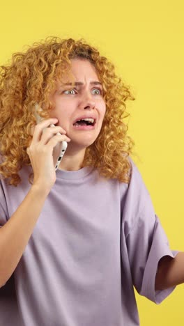 woman with a distressed expression talking on the phone