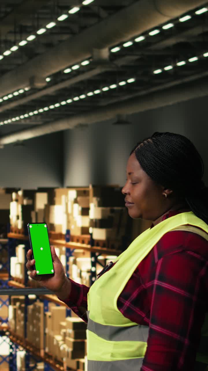 Vertical Video Vertical green screen, smartphone held by woman, logistics distribution hub