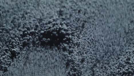 Close-up-of-fine-blue-powder-moving-rhythmically-through-sound