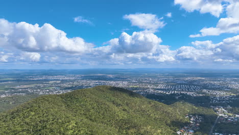 aerial departs from high altitude off mount archer's flanks towards rockhampton's large spreading suburbs of frenchville, berserker, koongal and norman gardens