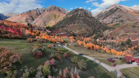 absolutely incredible dirt road and mountains back drop during peak fall colors in colorado with an airstream and jeep rolling down the road