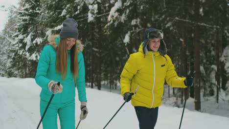 loving man and woman in slow motion in winter skiing in the woods. valentine day