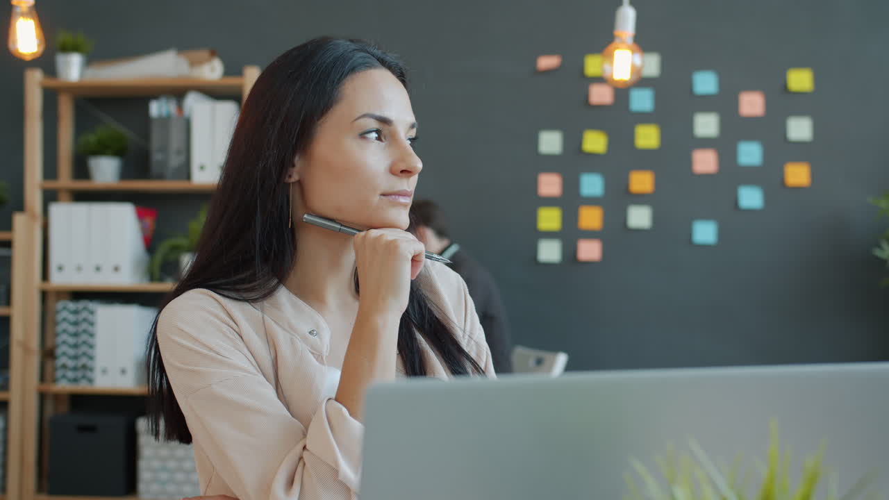 Woman Concentrating at Laptop in Office