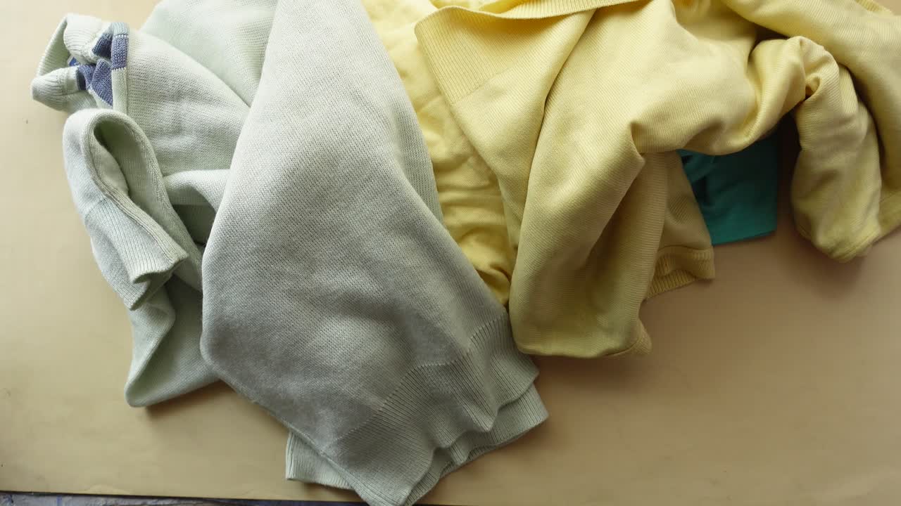 Crumpled Yellow and Teal Shirts on a Beige Background