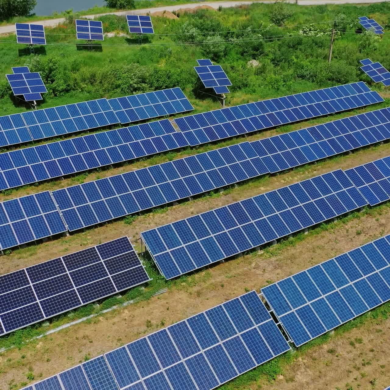 Innovative solar power station on field. Flight over solar collector sheets in countryside in sunny day. Renewable green energy. Aerial view.