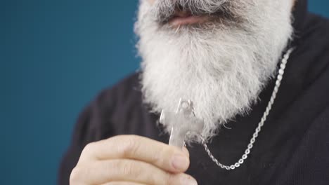 christian man kissing cross necklace and showing respect.