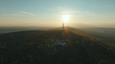 aerial view of a castle on a mountain at sunset