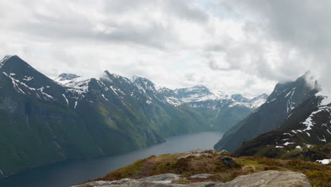 norwegian fjord with dramatic clouds surrounding mountain peaks at the west coast of norway at sunnmøre