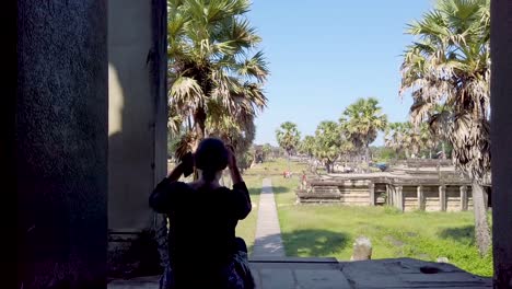 tourist sitting at angkor wat, siem reap cambodia, rear view