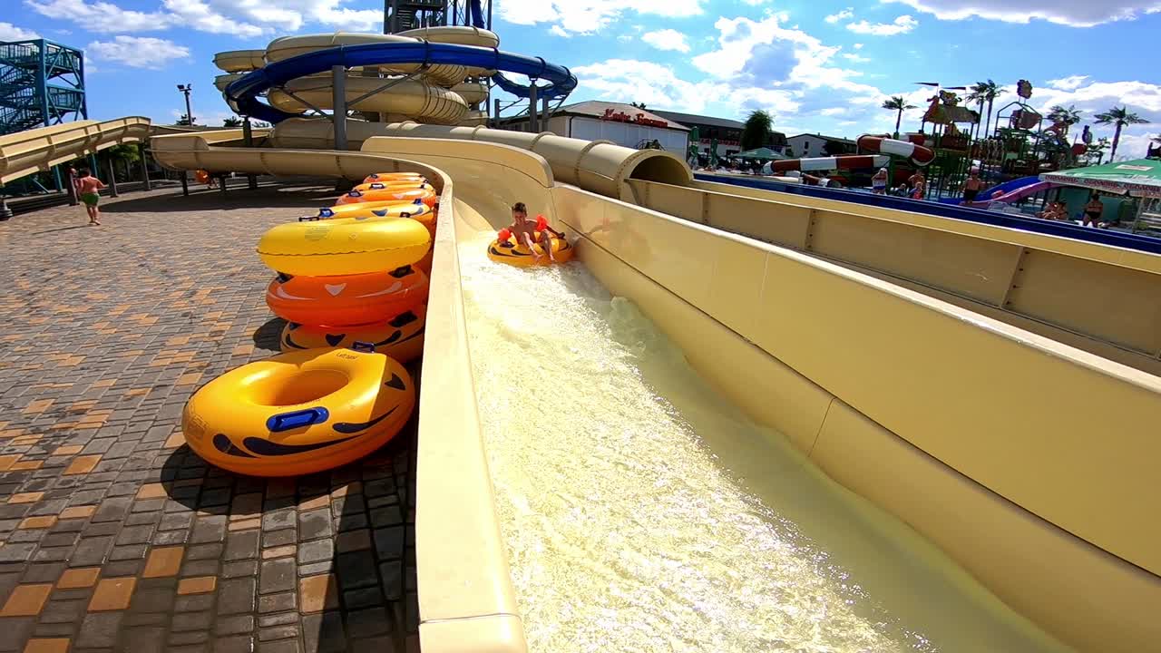 Teenager has fun in aquapark in the channel on a rubber ring.