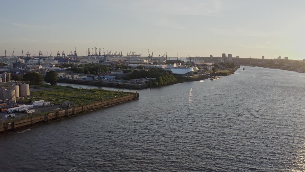 Amazing drone view of wide river and contemporary coastal town Hamburg against sundown sky in evening