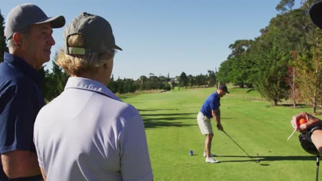 caucasian senior man practicing golf at golf course on a bright sunny day
